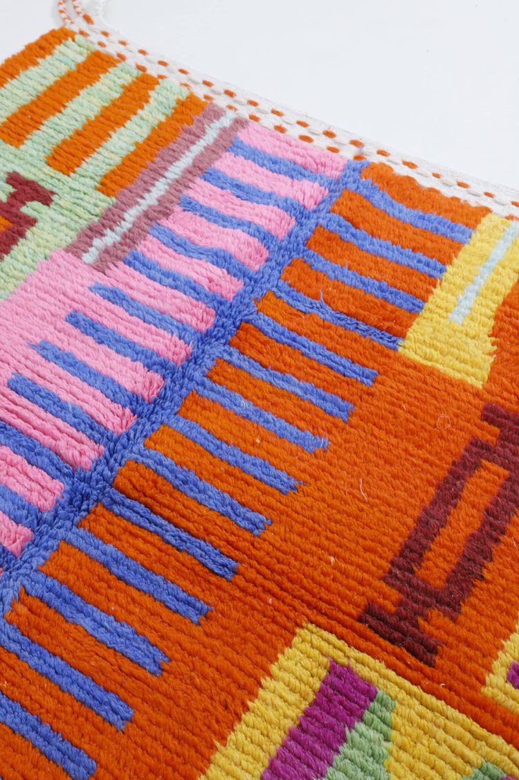 Handwoven Moroccan colorful rug with vibrant hues and intricate patterns, crafted from high-quality natural fibers for home decor.