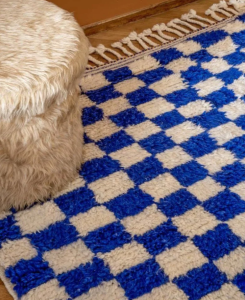 Blue and white checkered rug on hardwood floor.