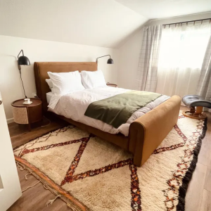 Colorful Azilal Moroccan Berber rug in a bohemian-styled bedroom.